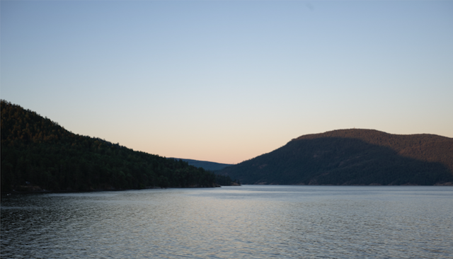 Salt Spring Island at golden hour — calm waters and forested hills under a warm sky